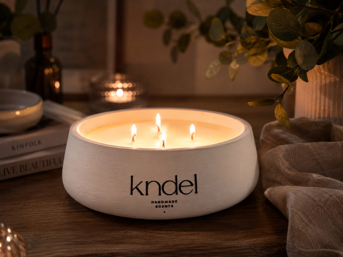 Vela artesanal KNDEL Albina blanca encendida en ambiente cálido